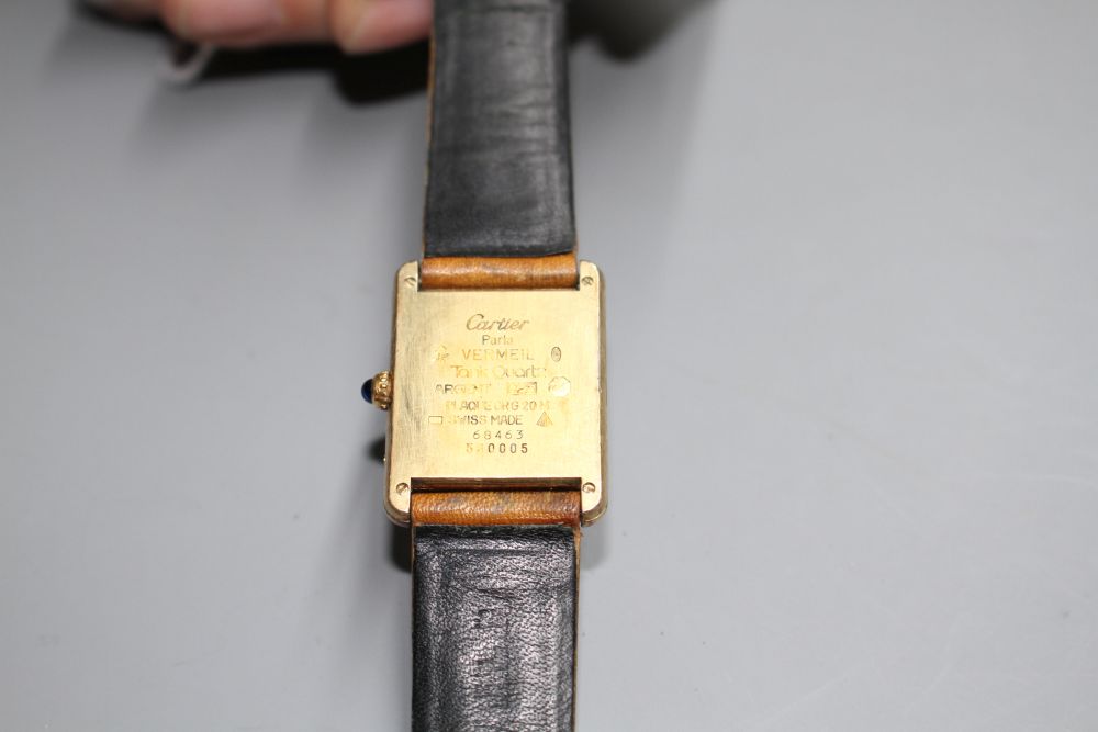 A ladys 925 gilt Must de Cartier Vermeil Tank quartz wrist watch, on associated strap.